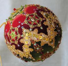 a red and green ball with gold decorations on it