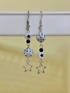 the earrings are decorated with black and white beads, stars and polka dots on them