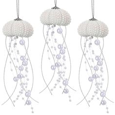 three white chandeliers with pearls hanging from them