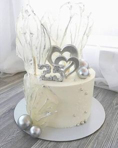 a white cake with silver decorations on top