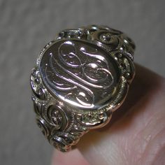 Such a beautiful ring for they guys but could be sized down for the ladies, within reason. This ring has fabulous scroll detailing on the shoulders. The oval face area is approx. 5/8 inches long and under 1/2 inch wide. Marks are the back 10 k and tested as such. Ring is heavy at 8.8 grams and approx. a size 13. This ring has been size up in the past. You can feel a slight ripple in the band in back as well as it being a bit thinner. Not an issue but an observation. The initials on the face look Victorian Oval Signet Ring With Polished Finish, Victorian Yellow Gold Engraved Ring With Polished Finish, Victorian 14k Gold Signet Ring With Polished Finish, Formal White Gold Jewelry With Initials, Victorian Engraved Ring With Polished Finish In 14k Gold, Victorian Engraved Signet Promise Ring, Victorian Yellow Gold Rings With Engraving Option, Antique Engraved Ring With Polished Finish For Formal Occasions, Victorian 14k Gold Engraved Ring With Polished Finish