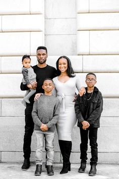 a family posing for a photo in front of a building with their child's parents