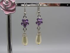 Pretty Dangle Pierced earrings with pretty purple stones arranged in a flower shape with a pearl shaped dropper. Your beautiful earrings will be carefully wrapped and packaged with love. Purple Pearl Earrings For Pierced Ears As A Gift, Purple Pearl Earrings As Gift, Elegant Purple Teardrop Flower Earrings, Purple Dangle Pearl Earrings As Gift, Purple Pearl Earrings Gift, Purple Teardrop Pearl Drop Earrings, Purple Pearl Earrings For Gift, Purple Dangle Pearl Drop Earrings, Purple Pearl Drop Earrings