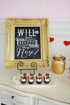 desserts are displayed in front of a framed chalkboard