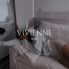 a woman laying on top of a bed next to a mirror with the word viviene