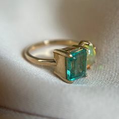 This gorgeous ring is handmade with traditional metalworking techniques Made with an emerald, opal, and 14k yellow gold Size 7.5 but inquire for size adjustments Multi-stone Emerald Diamond Ring For May Birthstone, Cabochon Emerald Ring Gift, Heirloom Yellow Gold Emerald Cabochon Ring, Gift Cabochon Emerald Ring, Multi-stone Emerald Ring As A Gift, Yellow Gold Emerald Cabochon Ring, Unique Yellow Gold Oval Emerald Ring, Gold Ethiopian Opal Heirloom Rings, Unique Oval Emerald Ring In Yellow Gold