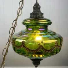 a green glass lamp hanging from a chain