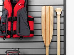 a life jacket and paddles are hanging on the wall next to an orange life vest