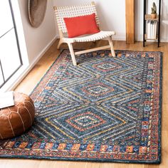 a room with a chair and rug on the floor