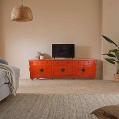 a living room with an orange cabinet and television