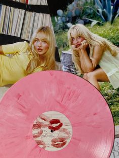 two women sitting next to each other in front of records