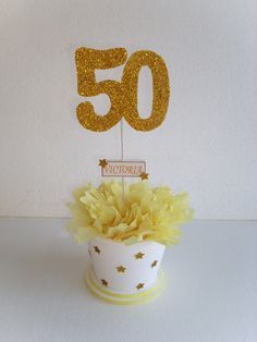 a white cup with some yellow flowers and a sign that says 50 is on it