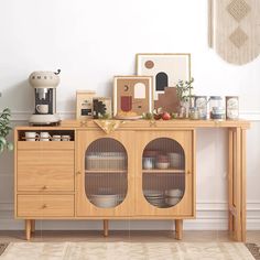 a wooden cabinet with glass doors in front of a white wall and rug on the floor