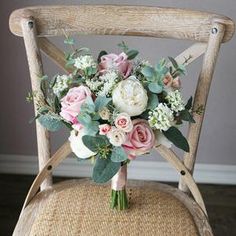 a bouquet of flowers sitting on top of a wooden chair