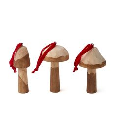 three wooden mushrooms with red ribbon tied around them