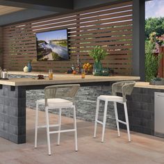 an outdoor bar with three stools and a television mounted on the wall behind it