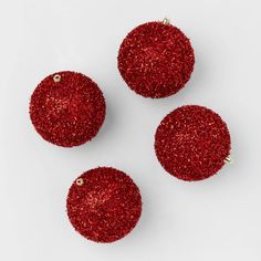 three red ornaments on a white surface