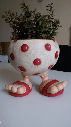 a potted plant sitting on top of a white table next to a pair of red shoes