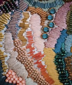 many different colored beaded items are arranged on top of each other in this close up photo