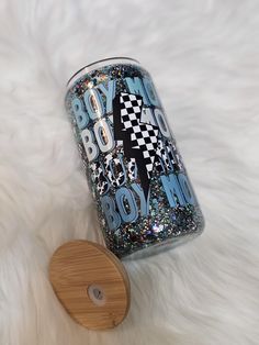 a can of booze sitting on top of a white fur covered floor next to a wooden coaster