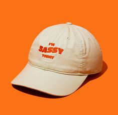 "Unleash your inner sass and let it speak volumes with our \"I'm Sassy Today\" embroidered dad hat. Crafted for those who embrace their boldness and wit, this hat isn't just an accessory--it's your cheeky sidekick on spirited days. Made from 100% organic cotton in a durable 3/1 twill, it's as resilient and forthright as you are. Perfect for adding a playful leap to your step and a twinkle to your outfit, it's the ultimate companion for expressing your vivacious spirit. Whether you're out for a c Kids Line, Organic Cotton Fabric, You Are Perfect, Style Expert, Dad Hat, Hat Making, Out Of Style, Trucker Cap, Dad Hats