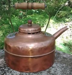 an old tea kettle sitting on top of a rock