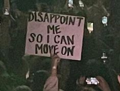 a person holding up a sign that says disappointment me so i can move on