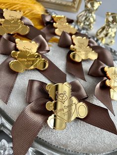 there are many gold and brown teddy bears on the cake, which is decorated with ribbons