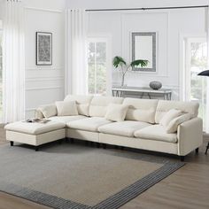 a living room with a large white sectional couch in the center and an area rug on the floor