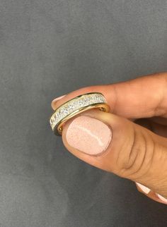 a woman's hand with two gold rings on top of her finger and the other ring