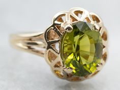 A gorgeous combination of polished gold and a lime green gemstone, these colors play beautifully off each other! The center is an oval-cut peridot, with great depth of color and lovely sparkle. Held in a scalloped filigree setting, the metal work around the stone gives this ring an antique old-world feel.Metal: 10K Yellow GoldGem: Peridot 2.02 CaratsGem Measurements: 6.9 x 8.9 mm, OvalRing Size: 6.50Marks: “B&F 10K” Stamped on the inside band Elegant Lime Green Jewelry With Center Stone, Elegant Lime Green Oval Rings, Oval Peridot Green Jewelry, Oval Green Peridot Jewelry, Green Oval Peridot Jewelry, Lime Green Oval Jewelry For May Birthstone, Classic Lime Green Oval Jewelry, Green Oval Filigree Ring, Oval Peridot Heirloom Jewelry