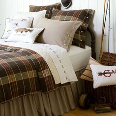 a bed with plaid comforter and pillows on it