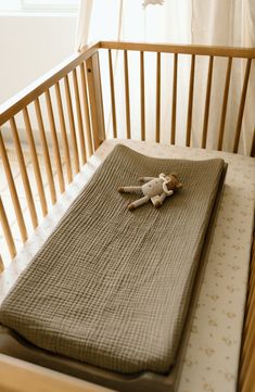 a stuffed animal laying on top of a baby crib