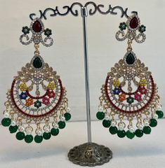 Dazzle in the rich tapestry of culture with these exquisite Multicolor Traditional Chandelier Earrings. A stunning array of vibrant gemstones and delicate pearls are meticulously arranged in an ethnic motif, creating an eye-catching display of elegance and craftsmanship. Each earring features a luxurious cascade of black and white pearls, adding a classic touch to the ornate design. Perfect for adding a splash of color to evening wear or elevating traditional attire, these earrings are a celebra Multicolor Chandbali Jhumkas With Intricate Design, Multicolor Temple Jewelry Bridal Earrings With Intricate Design, Multicolor Intricate Chandbali Bridal Earrings, Multicolor Intricate Bridal Earrings For Diwali, Multicolor Kundan Bridal Earrings With Intricate Design, Multicolor Chandbali Bridal Earrings With Intricate Design, Multicolor Bridal Earrings With Intricate Design For Diwali, Multicolor Chandbalis With Intricate Temple Design, Traditional Jeweled Dangle Danglers