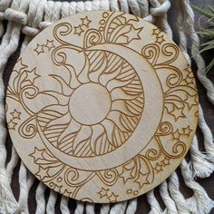 a wooden ornament with an image of the moon and stars on it's side