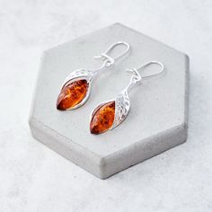 "Leaf Baltic amber and sterling silver statement earrings This lightweight pair of earrings is made of Baltic amber stones and perforated sterling silver (.925) elements. The earrings are 4.2cm (1.65\") long, 1.1cm (0.51\") wide with classic amber cabochons placed in a silver frame. Earrings are finished with French hooks. Check out this matching pendant: https://www.etsy.com/uk/listing/851861336/ Individually selected amber cabochons have been placed in exclusive, hand-crafted, hallmarked sterl Frame Earrings, Amber Bead Necklace, Vintage Gold Earrings, Silver Statement Earrings, Amber Earrings, Gold Statement Earrings, Natural Amber, Earrings Elegant, Classic Jewelry