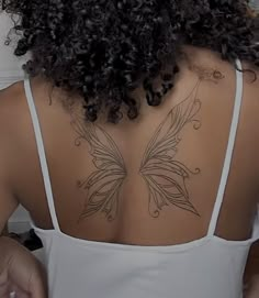 the back of a woman's shoulder with a butterfly tattoo on her upper half