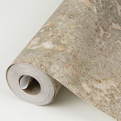 a roll of carpet with brown and white speckles on the floor next to it