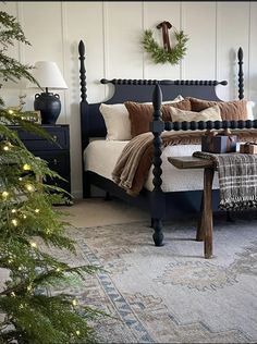 a bedroom decorated for christmas with lights on the bed and wreaths hanging from the wall