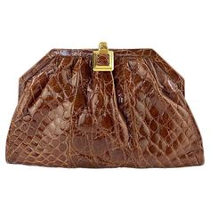 Presenting a stunning saddle brown Gucci crocodile convertible crossbody. This beautiful bag is constructed entirely of genuine glossy crocodile leather and is finished with gold accent hardware. From the Spring/Summer 1987 collection, this bag was prominently featured in a Gucci advertisement that year. The bag can be a clutch or crossbody with a convertible gold chain. This classic bag is in like-new condition and is the perfect addition to any personal wardrobe or collection. Approximate meas Gucci Advertisement, Expensive Bag, Popular Handbags, Large Clutch, Plush Bags, Gucci Bamboo, Gold Bag, Luxury Purses, Saddle Brown