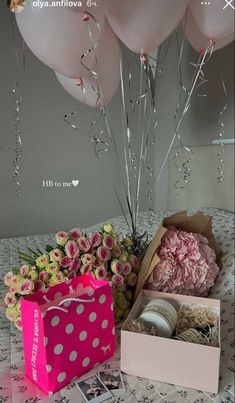 pink flowers and balloons are on the table