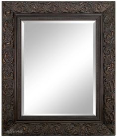 a large mirror with an ornate design on it's sides and a dark wood frame