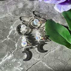 Shine bright like the goddess you are! These celestial moon earrings are sure to shine, and will give you a surprise with the sunlight.   Made with stainless steel and paired with a glass crystal bead, these earrings give a sparkle when the sun hits them, reminding you of a sun catcher! Light weight and perfect for every day wear or when you want to rock your celestial goddess side. Celestial Silver Pierced Crystal Earrings, Silver Celestial Crystal Earrings For Pierced Ears, Nickel-free Celestial Crystal Earrings, Celestial Moon Charm Crystal Earrings, Silver Moon-shaped Celestial Earrings, Silver Celestial Crystal Earrings, Silver Moon-shaped Celestial Crystal Earrings, Silver Moon Shaped Celestial Crystal Earrings, Silver Moon Shaped Crystal Earrings