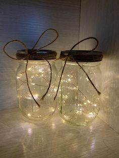 two mason jars with fairy lights in them