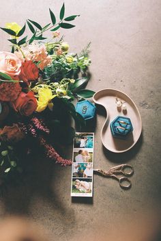 a bouquet of flowers and two dices on a plate next to some other items