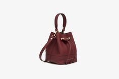 A modern take on the classic bucket bag, our best-selling osette is your perfect everyday companion. Deceptively spacious, the soft structure is handcrafted in spain and features an elegant drawstring closure, complete with our signature music bar. This compact yet versatile silhouette can be carried in hand by the leather top-handle, or styled as a crossbody bag with the detachable leather strap - for elegant ease in your everyday. Introducing the richness of our oxblood capsule, a new burgundy Elegant Bucket Bag With Removable Pouch For Shopping, Elegant Bucket Bag With Removable Pouch And Tote Shape, Elegant Bucket Tote Bag With Removable Pouch, Elegant Bucket Bag With Detachable Strap For Shopping, Elegant Tote Bucket Bag With Removable Pouch, Elegant Leather Handle Bucket Tote Bag, Elegant Bucket Bag With Leather Handles For Shopping, Elegant Leather Handles Shoulder Bucket Bag, Elegant Leather Bucket Bag For Shopping