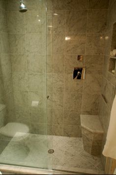 a bathroom with a glass shower door next to a toilet