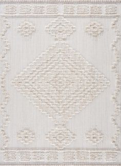 a white rug with an intricate design on the front and back side, in shades of beige