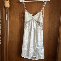 Elegant White Slip Dress With Delicate Lace Trim. Features Adjustable Straps And A Flattering Fit. Silk Summer Sleepwear With Lace Trim, Summer Silk Sleepwear With Lace Trim, Sleeveless Silk Nightgown For Summer, Summer Sleeveless Silk Nightgown, Silk Summer Party Sleepwear, V-neck Mini Dress For Wedding Night In Spring, Summer Loungewear Mini Dress With Lace Trim, White Sleeveless Nightgown For Party, Sleeveless Summer Mini Dress For Wedding Night