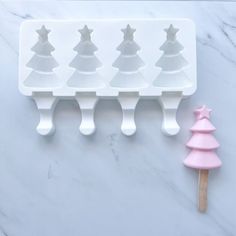 an ice tray with christmas trees on it next to a popsicle molding tool